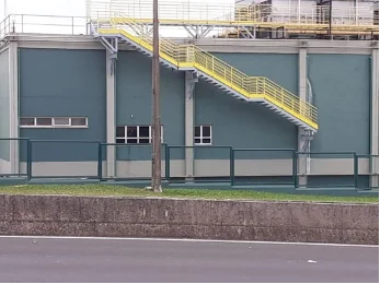 Escada e plataforma metálicas em fachada industrial